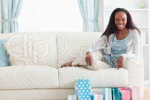 Woman on sofa with shopping in front of her