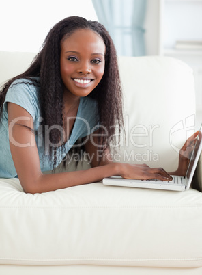 Close up of woman lying on the sofa with her laptop Close up of woman lying on the sofa with her laptop
