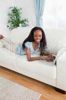 Woman lying on the sofa using her notebook