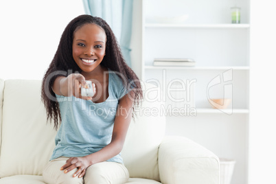 Woman on couch using remote control