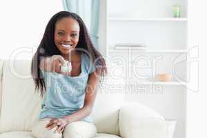 Woman on couch using remote control