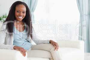 Woman sitting on sofa with legs folded