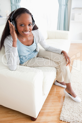 Woman sitting on sofa with headphones on