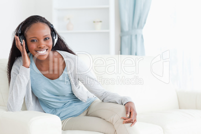Woman sitting on couch with headphones on
