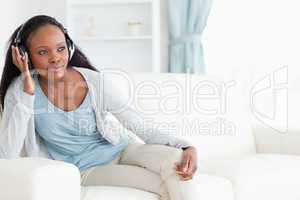 Woman leaning against armrest with headphones on
