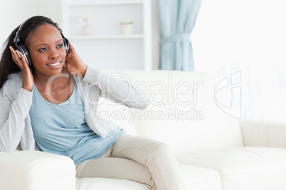 Woman enjoys music on the sofa