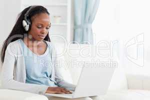 Woman with headphones on working on laptop