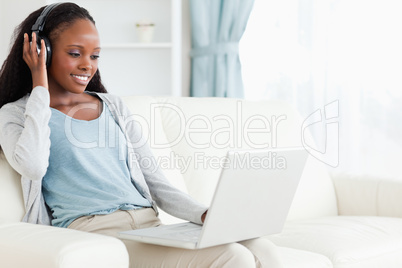 Woman listening to music while using her notebook