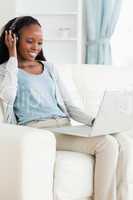 Woman listening to music while using her laptop