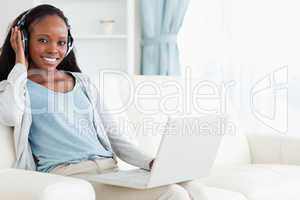 Woman using her laptop while listening to music