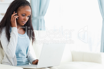 Woman on the phone while using laptop