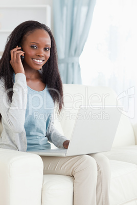 Woman on the phone while working on notebook