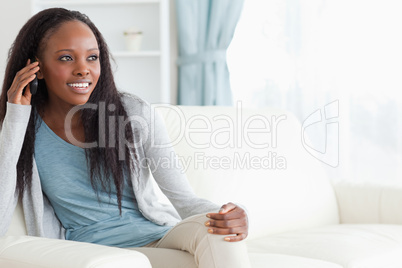 Woman sitting on couch while using her phone