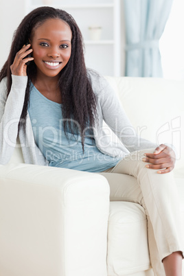 Woman sitting on couch while using her mobile phone