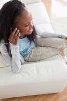 Close up of woman using her phone on sofa