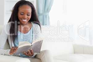 Woman on sofa with book
