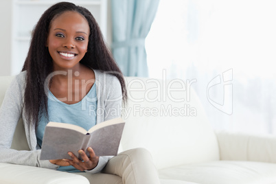 Woman on couch with book