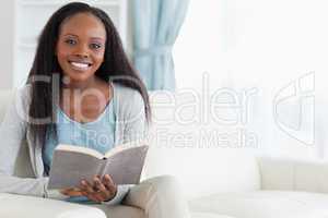 Woman on couch with book