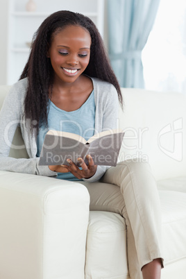 Woman with book on couch