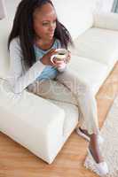 Woman drinking coffee on sofa