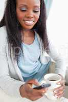 Close up of woman texting while having a caffee