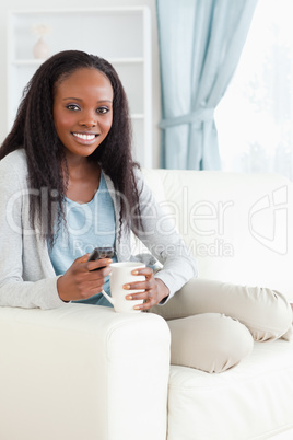 Woman writing text message while having a coffee