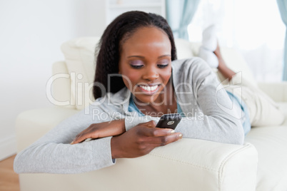 Woman reading text message on sofa Woman reading text message on sofa