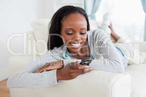 Woman reading text message on sofa