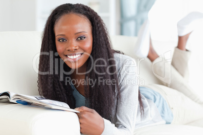 Woman with booklet on sofa