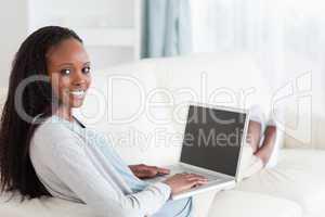 Smiling woman with notebook on sofa