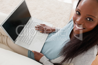 Smiling woman with laptop on sofa