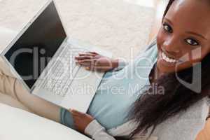 Smiling woman with laptop on sofa