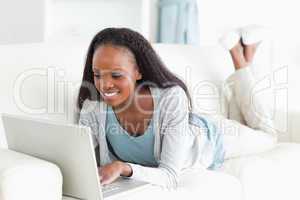 Woman on her couch surfing the internet