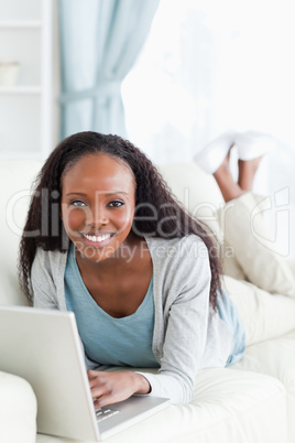 Close up of woman on couch surfing the internet