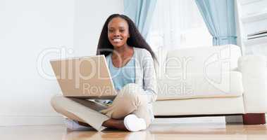 Woman sitting on the floor using her laptop