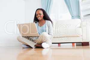 Woman sitting on the floor using her notebook