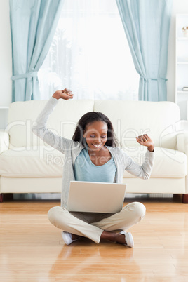 Woman stretching while sitting on the floor with notebook