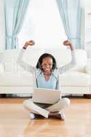 Woman stretching while sitting on the floor with laptop