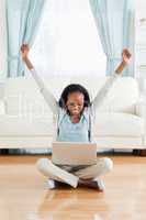 Woman stretching while sitting on the floor with her laptop