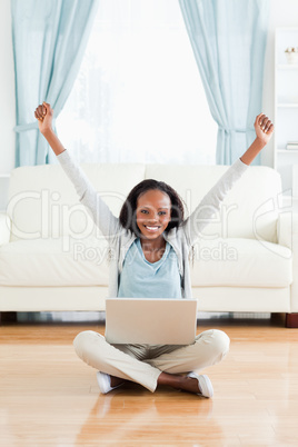 Woman stretching while sitting on the floor with her notebook