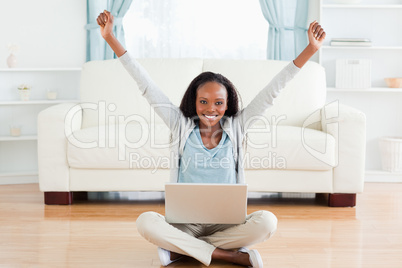 Woman stretching while sitting on the floor working on her lapto