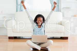 Woman stretching while sitting on the floor working on her noteb