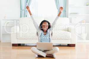 Woman stretching while sitting on the floor working on laptop
