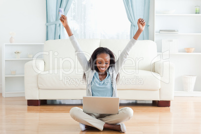 Woman stretching while sitting on the floor working on notebook