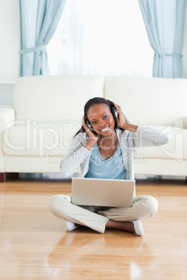 Woman sitting on the floor listening to music