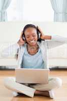 Close up of woman sitting on the floor listening to music