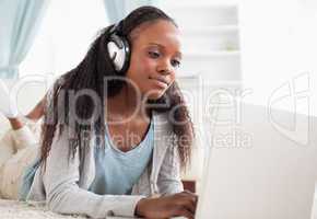 Close up of woman lying on the floor with her notebook enjoying