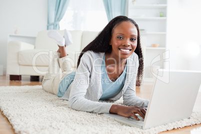 Woman lying on the floor with her laptop