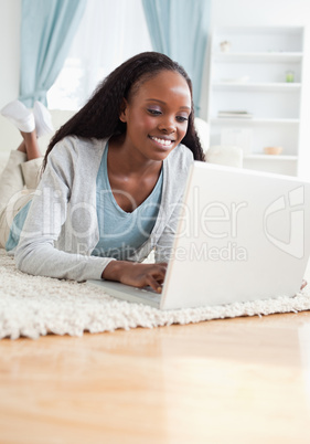 Close up of woman lying on the floor with her laptop