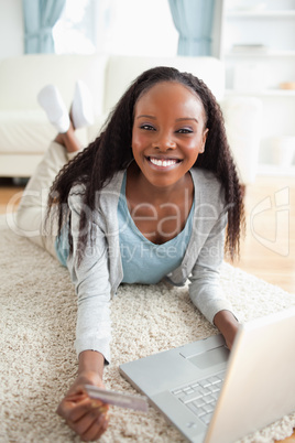 Close up of woman lying on the floor with her notebook shopping